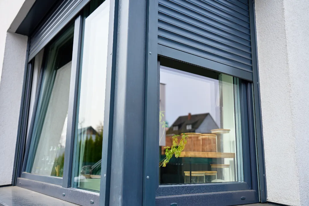 Dark grey external roller shutter fitted above a modern window.